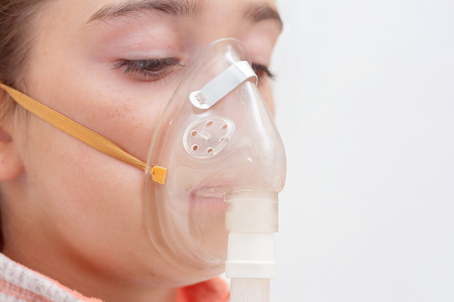 A woman breathes through a nebuliser