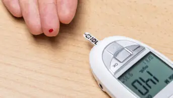 A person has their cholesterol measured with a device