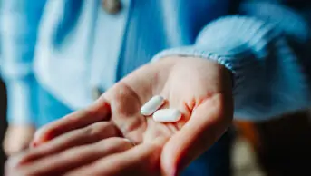 An older person holds two tablets