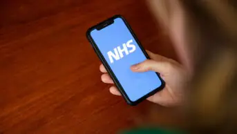 A woman uses the NHS App on her phone