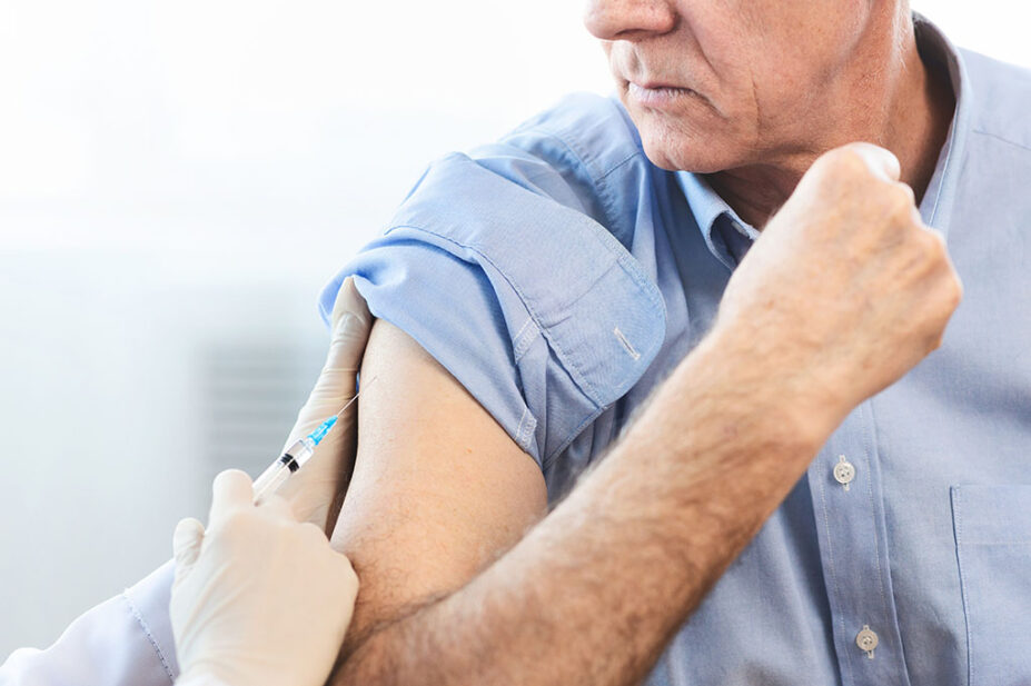 Healthcare professional administers flu vaccine to a male patient