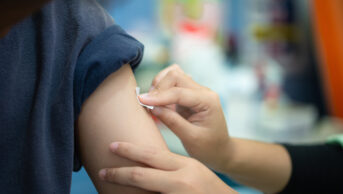 A healthcare professional applies a plaster after a flu vaccination