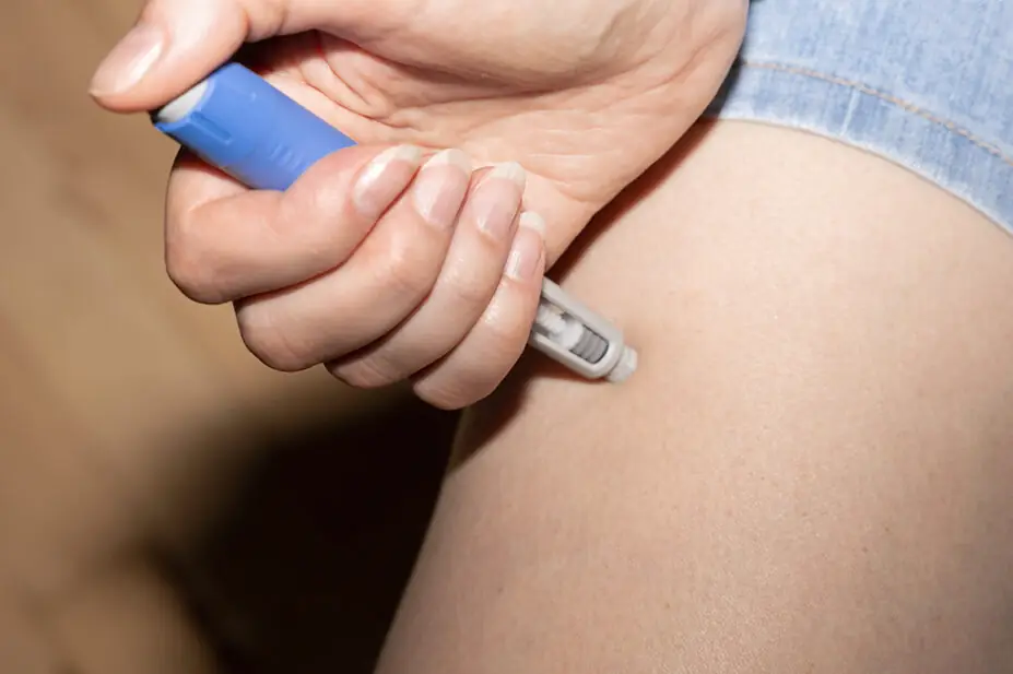 A woman injects herself with a weight-loss pen