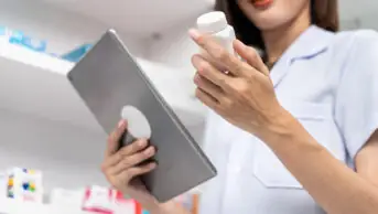 A pharmacist uses a tablet to examine medication