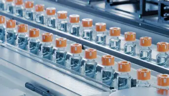 Conveyor belt with glass vials at pharmaceutical factory