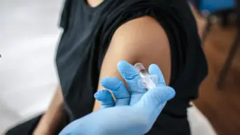 A female patient receives a vaccine injection in her arm