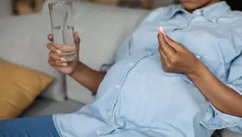 Woman taking sodium valproate tablet