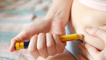 A woman injects diabetes medicine into her stomach