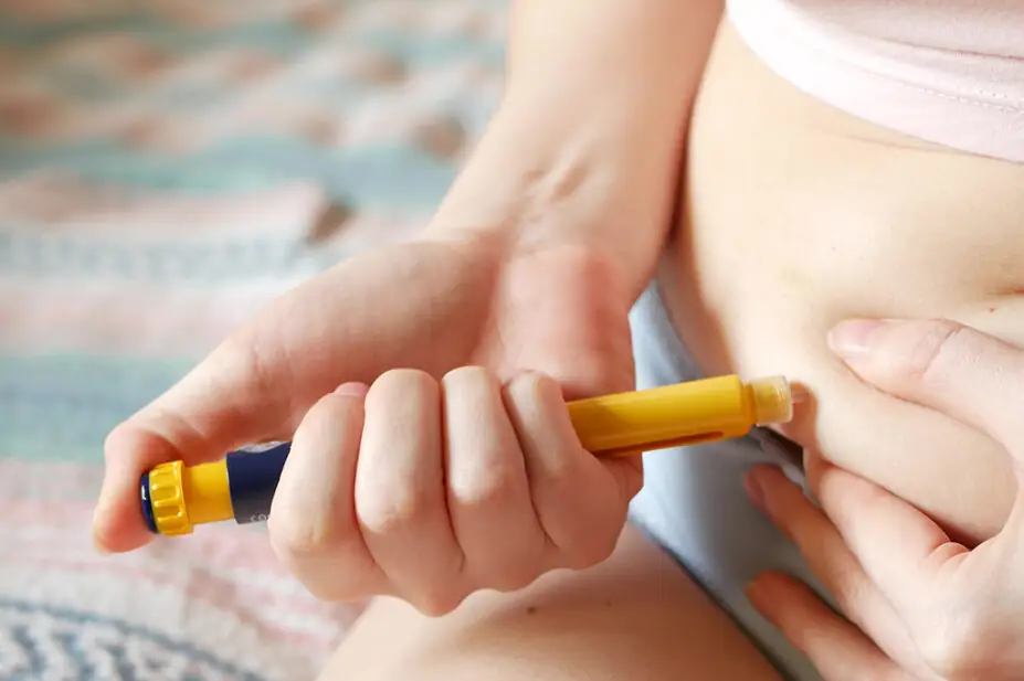 A woman injects diabetes medicine into her stomach