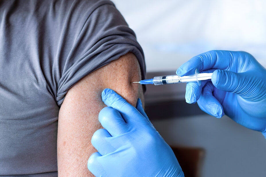 A man receives a vaccine from a healthcare professional