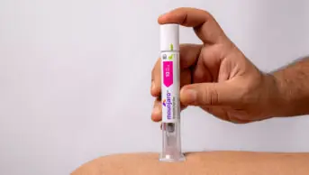 A man holds a Mounjaro weight-loss pen against his thigh