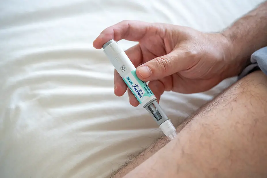 A man uses a Wegovy injection pen