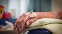 A person receives medication through an IV drip
