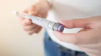 Diabetes patient turn knob on end of insulin pen