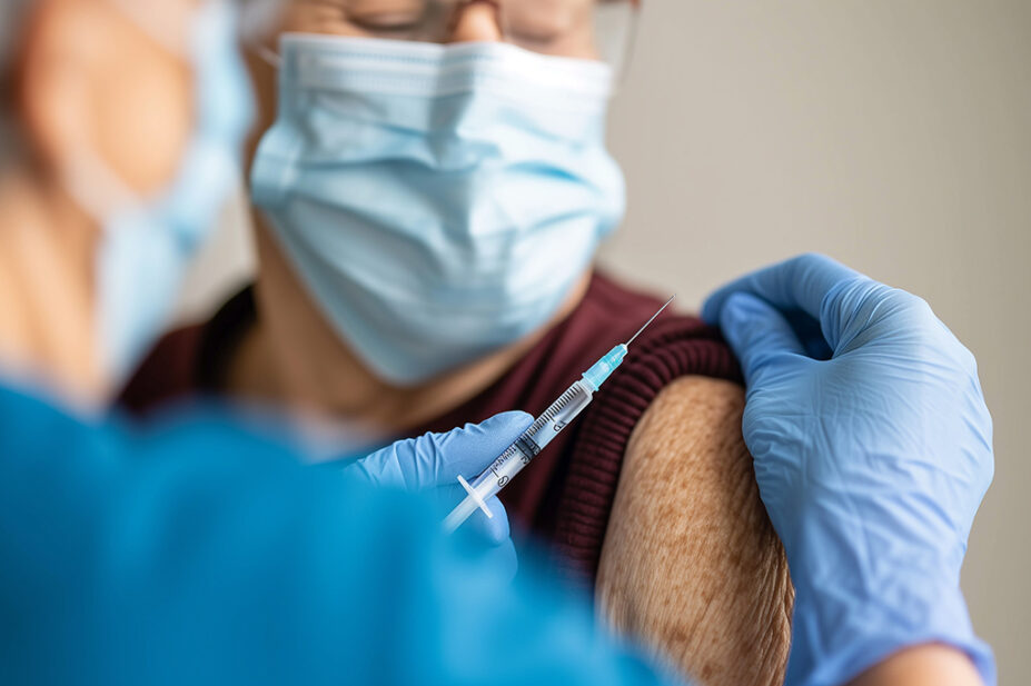 Older woman receiving a vaccination in upper arm