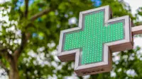 The neon sign outside of a community pharmacy