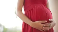 Image of pregnant woman touching her belly with hands