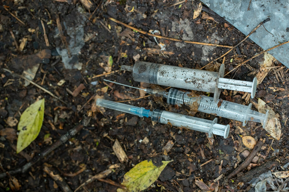 Used syringes on ground outside