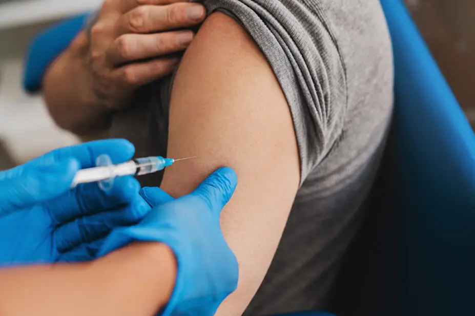 A man receives an injection in his arm