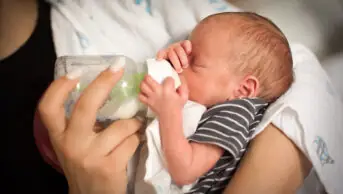 A newborn baby being fed milk