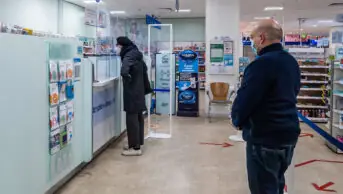 Customers waiting to speak to pharmacist in a pharmacy