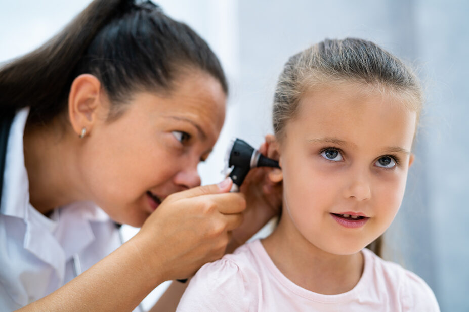 A healthcare professional checks a patient's ear