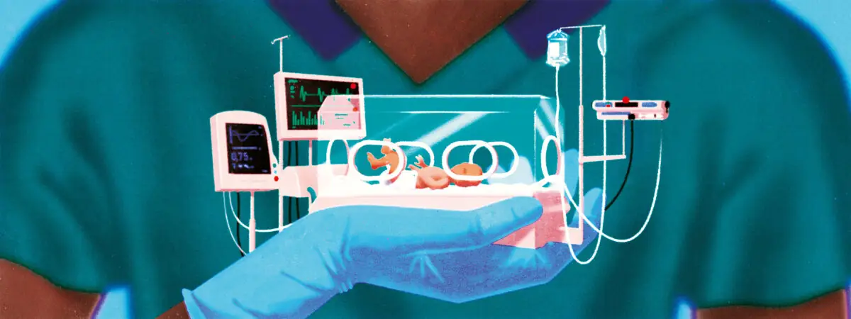 A pharmacist holds a baby in intensive care
