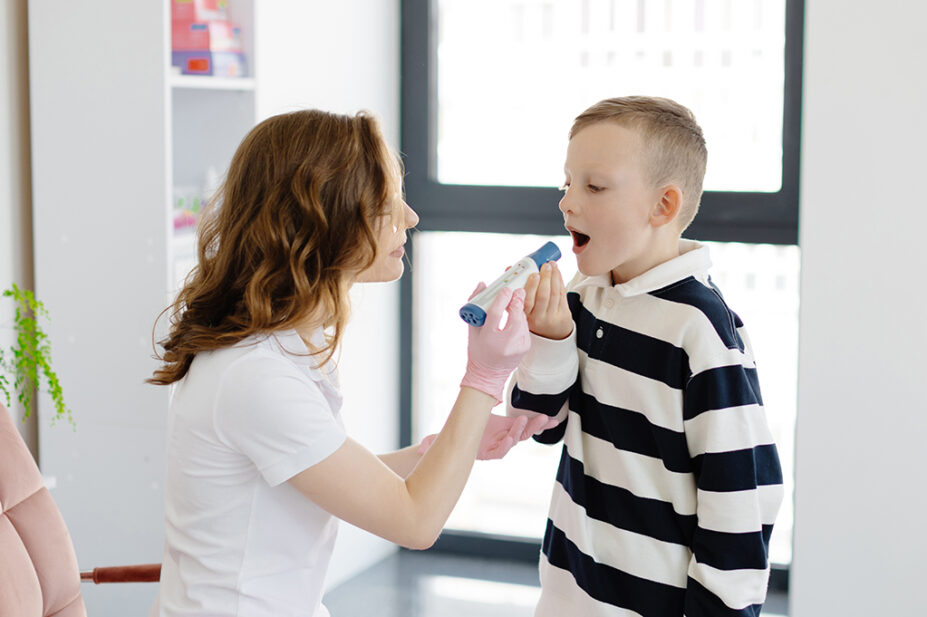 A healthcare professional conducts a peak flow asthma test with a patient