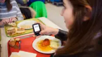 Young woman checking her blood sugar levels after eating a meal