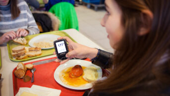 Young woman checking her blood sugar levels after eating a meal