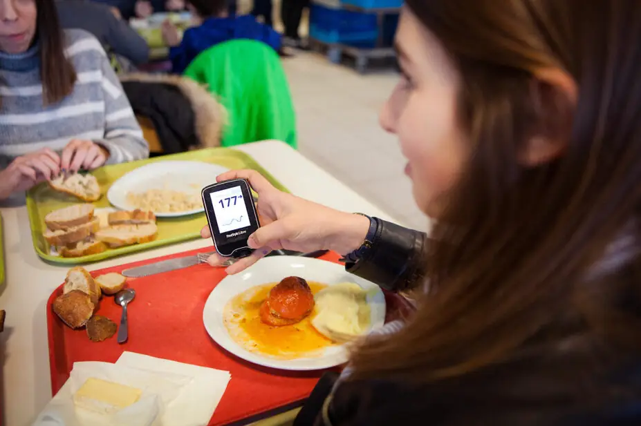 Young woman checking her blood sugar levels after eating a meal