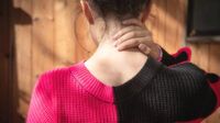 Young woman rubbing her neck in pain