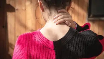 Young woman rubbing her neck in pain