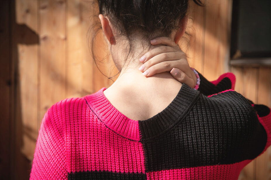 Young woman rubbing her neck in pain