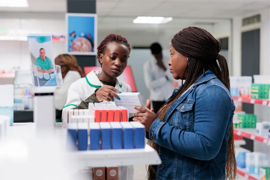 Photo of a patient talking to a pharmacist within a pharmacy