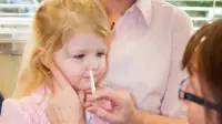 Toddler having nasal flu vaccine