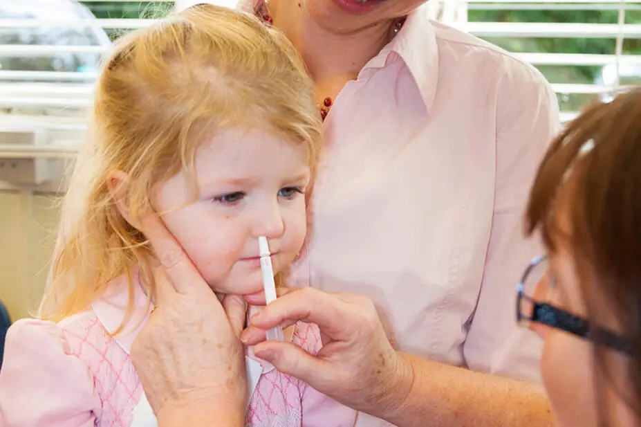 Toddler having nasal flu vaccine