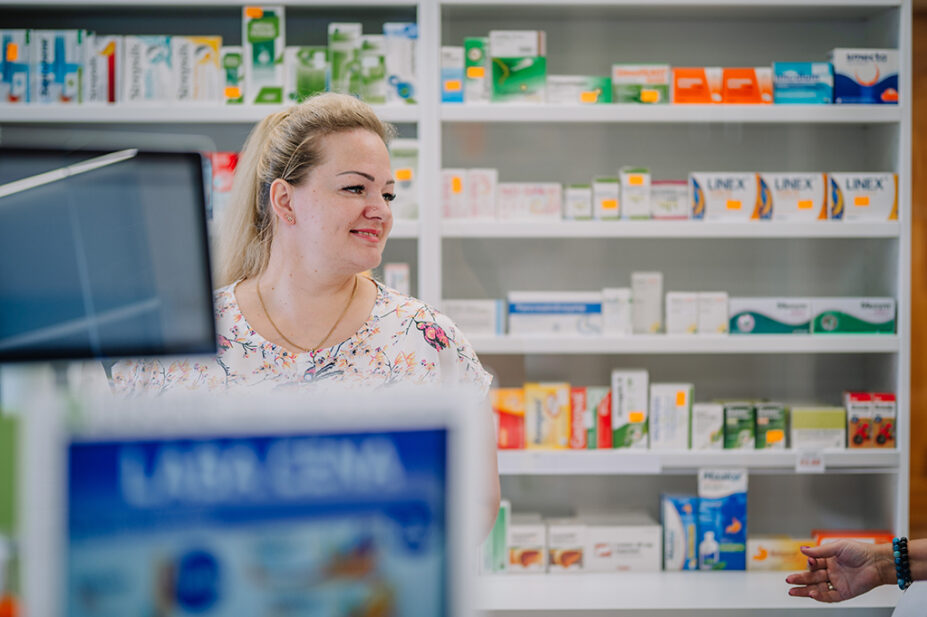 Pharmacy worker behind prescription counter