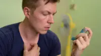 A man uses an inhaler for asthma