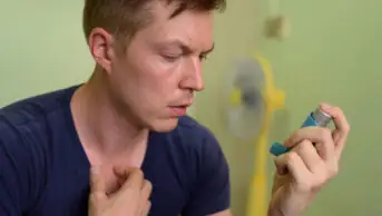 A man uses an inhaler for asthma