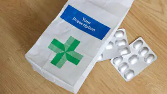 An NHS prescription bag with two packets of medicines