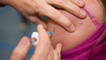 A healthcare professional gives a patient a vaccination
