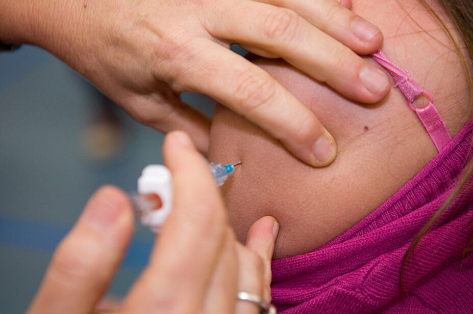 A healthcare professional gives a patient a vaccination