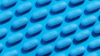 PrEP pills laid out in a rows on a blue background