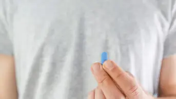 A man holds a pre-exposure prophylaxis pill