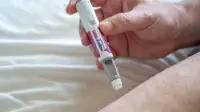 A man uses a Wegovy weight-loss injection in his thigh
