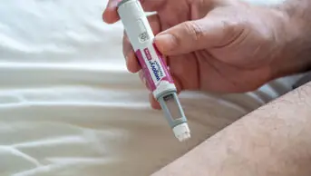 A man uses a Wegovy weight-loss injection in his thigh
