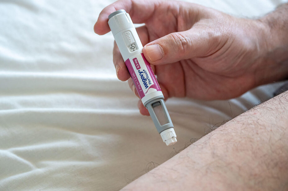A man uses a Wegovy weight-loss injection in his thigh