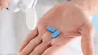 Man holding PrEP tablets in palm of hand