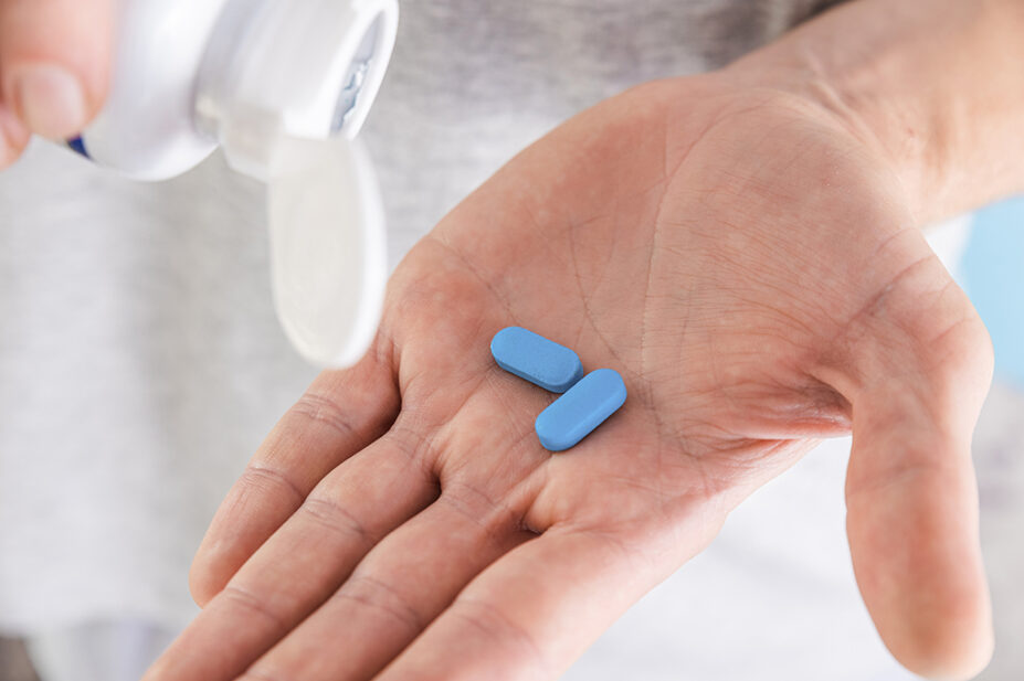 Man holding PrEP tablets in palm of hand